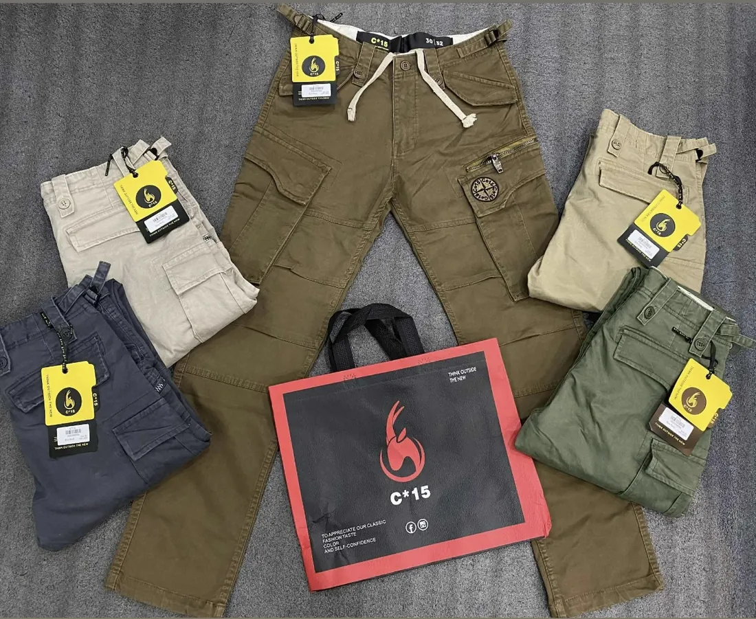 Flat lay of C-15 cargo cotton pants in olive, khaki and beige with swing tags and the C-15 bag