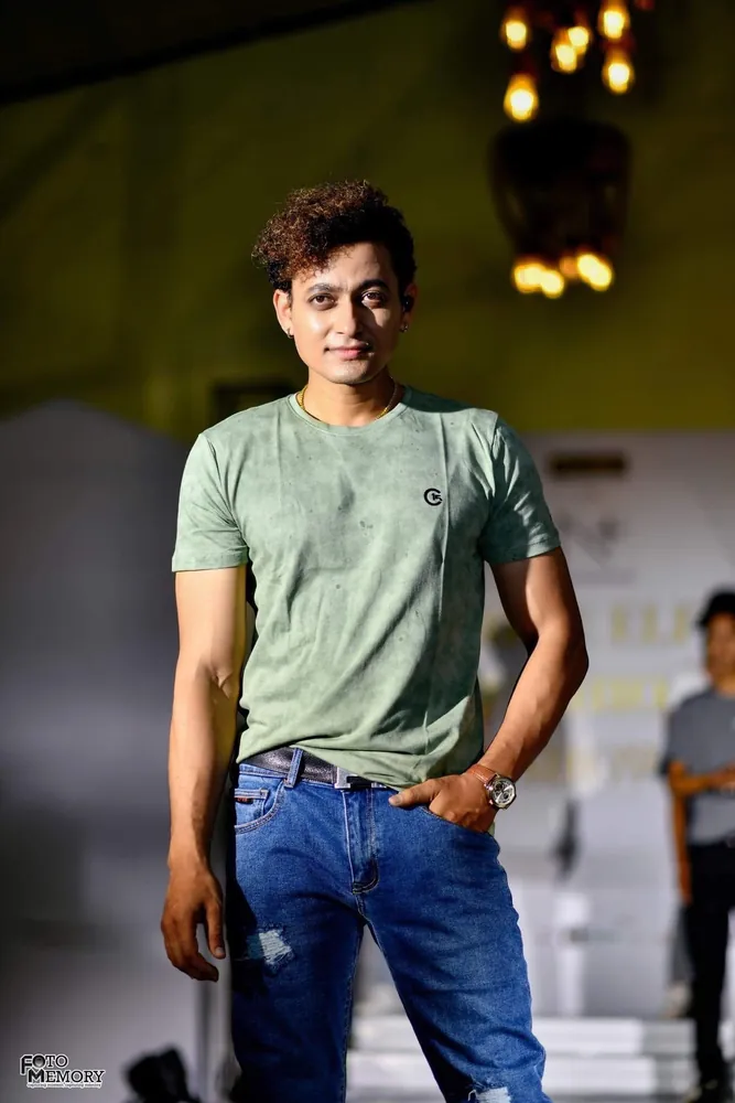 Model in a sage-green C-15 tee and mid-blue jeans at an evening event