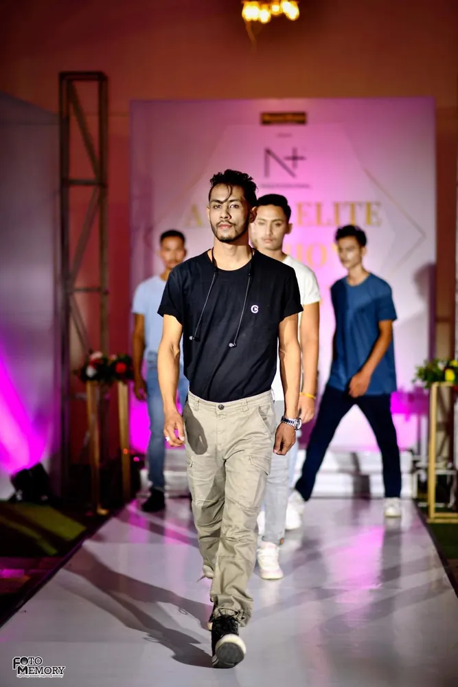 Models walking a fashion show runway in C-15 menswear, a black tee and khaki chinos leading