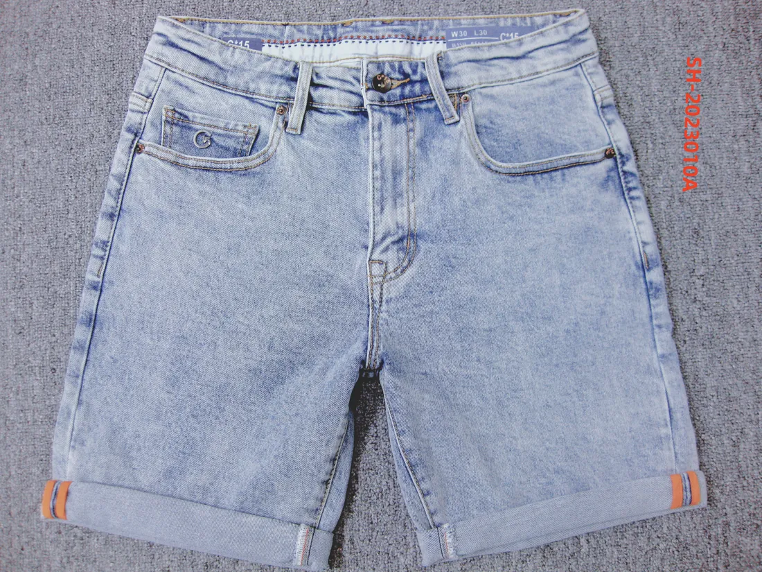 C-15 acid-wash denim half pants with rolled cuffs photographed on a grey carpet