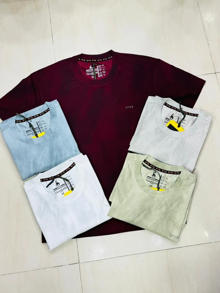 Maroon C-Fifteen t-shirt laid out with folded pastel colourways on tile