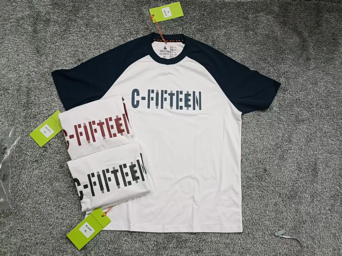 White and navy raglan C-Fifteen t-shirt with tags photographed on grey carpet