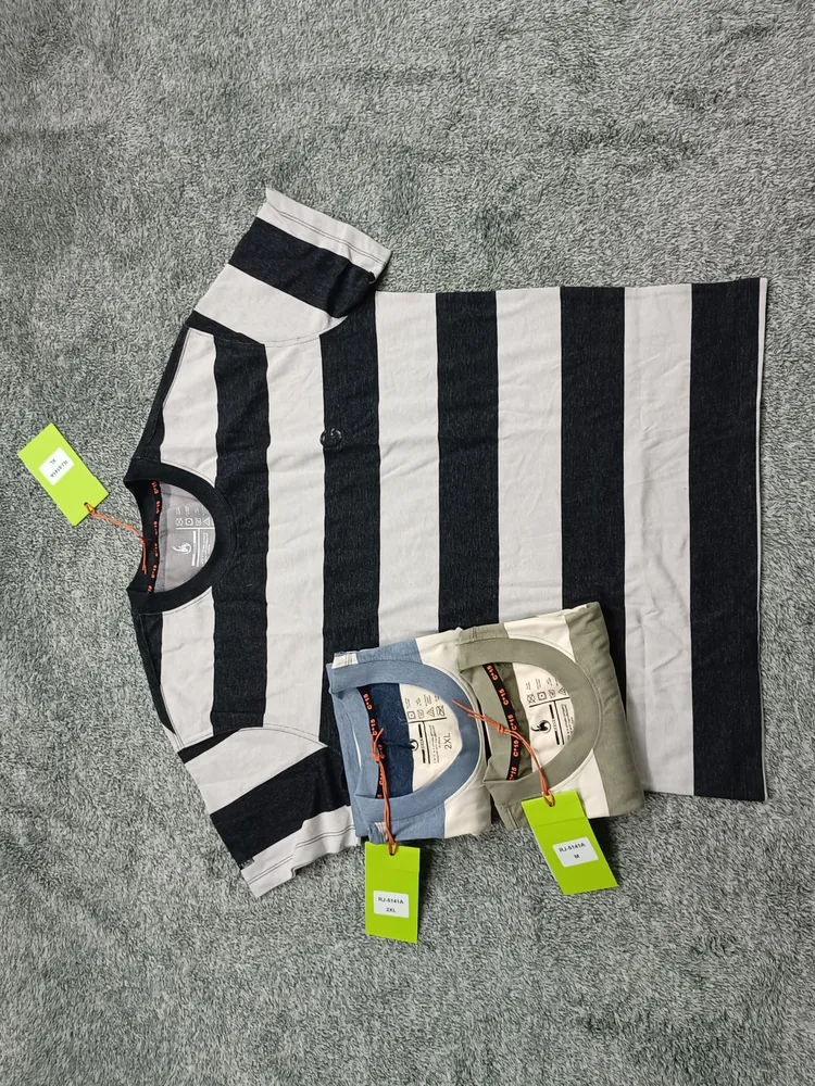 Black and white wide-stripe C-15 t-shirt with folded striped colourways on carpet